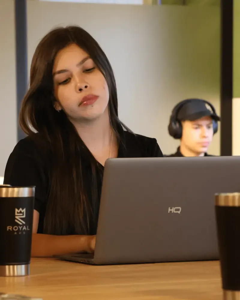 Integrante do time Royal concentrada no laptop